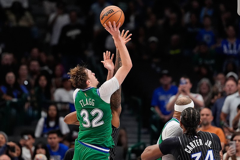 Dallas Mavericks forward Cooper Flagg (32) is fouled by Orlando Magic's Jamal Cain, rear, as Flagg sinks a basket for his 50th point of the game late in the second half of an NBA basketball game Friday, April 3, 2026, in Dallas. (AP Photo/Tony Gutierrez)