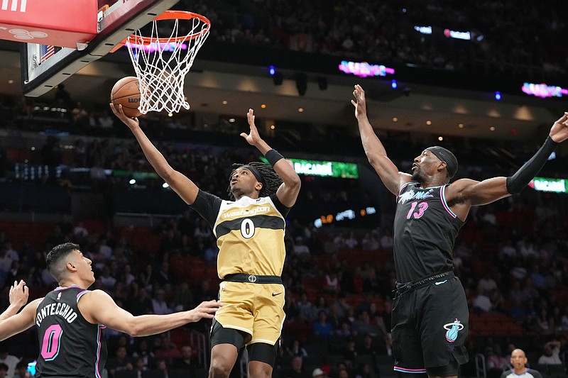 Washington Wizards guard Bilal Coulibaly (0) aims to score as Miami Heat forward Simone Fontecchio (0) and center Bam Adebayo (13) defend during the first half of an NBA basketball game Saturday, April 4, 2026, in Miami. (AP Photo/Marta Lavandier)