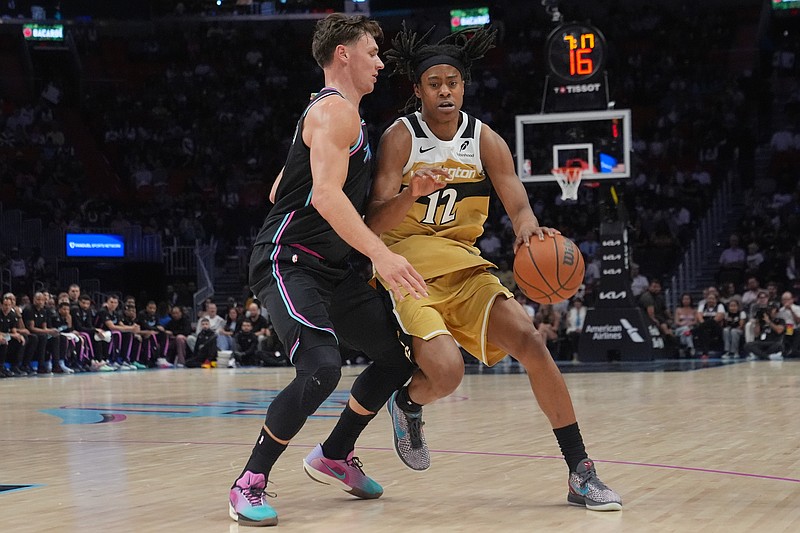 Miami Heat guard Pelle Larsson (9) defends Washington Wizards guard Tre Johnson (12) during the first half of an NBA basketball game Saturday, April 4, 2026, in Miami. (AP Photo/Marta Lavandier)