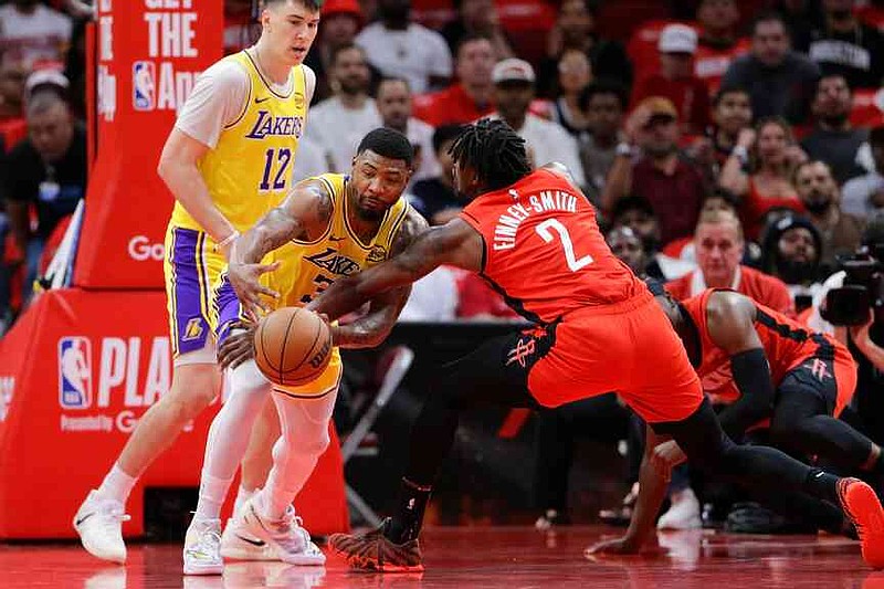 Houston Rockets forward Dorian Finney-Smith (2) knocks away the ball from Los Angeles Lakers guard Marcus Smart, center, as forward Jake LaRavia (12) looks on during the first half in Game 3 of a first-round NBA playoffs basketball series Friday April 24, 2026, in Houston. (AP Photo/Michael Wyke)