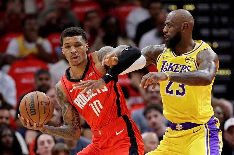 Houston Rockets forward Jabari Smith Jr. (10) becomes entangled with Los Angeles Lakers forward LeBron James (23) as he drives to the basket during the first half of Game 3 in a first-round NBA playoffs basketball series Friday April 24, 2026, in Houston. (AP Photo/Michael Wyke)