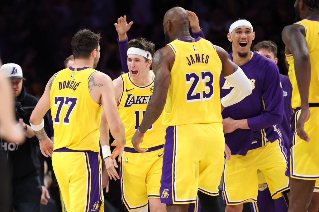Los Angeles Lakers players including LeBron James celebrate during a game against the Denver Nuggets.