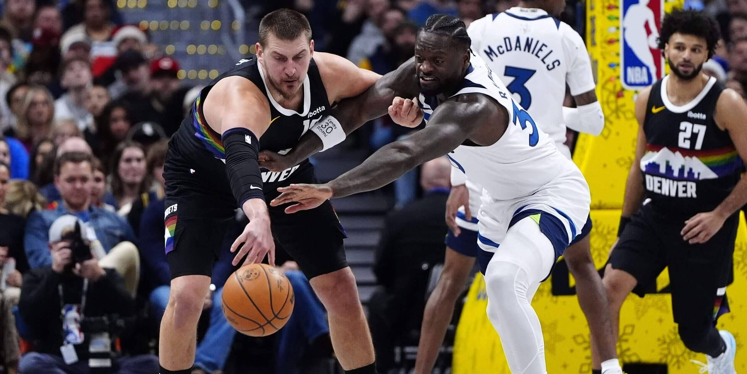 Denver's Nikola Jokić is guarded by Minnesota's Julius Randle.