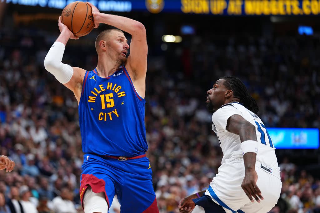 Nuggets center Nikola Jokic looks to pass the ball over Timberwolves center Naz Reid. AP