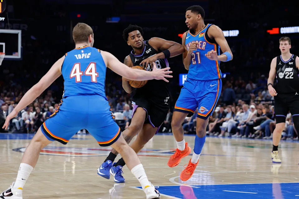 Apr 5, 2026; Oklahoma City, Oklahoma, USA; Utah Jazz forward Brice Sensabaugh (28) drives between Oklahoma City Thunder guard Nikola Topic (44) and guard Aaron Wiggins (21) during the second half at Paycom Center. Mandatory Credit: Alonzo Adams-Imagn Images