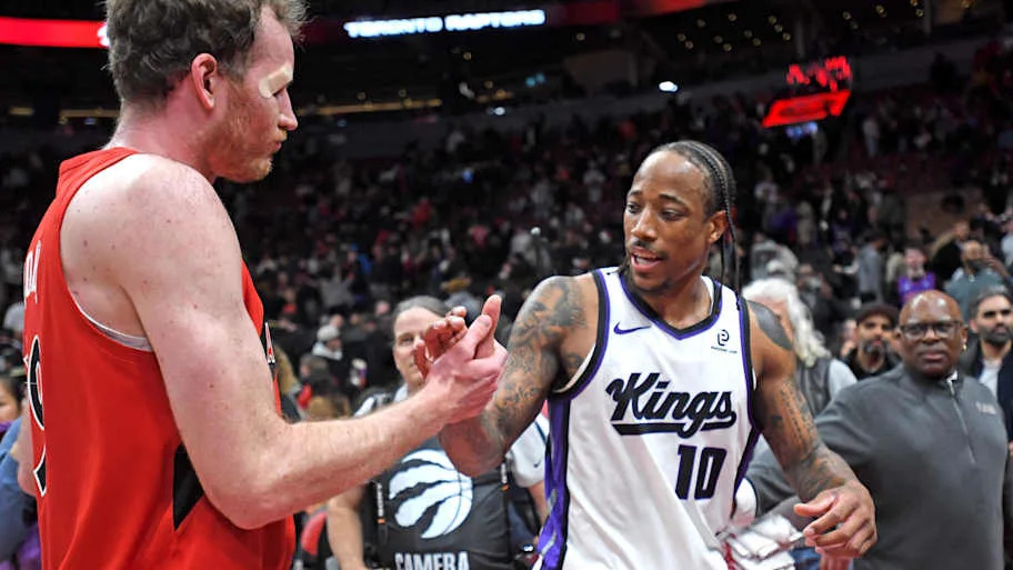 Sacramento Kings forward DeMar DeRozan shakes hands with Toronto Raptors center Jakob Poeltl