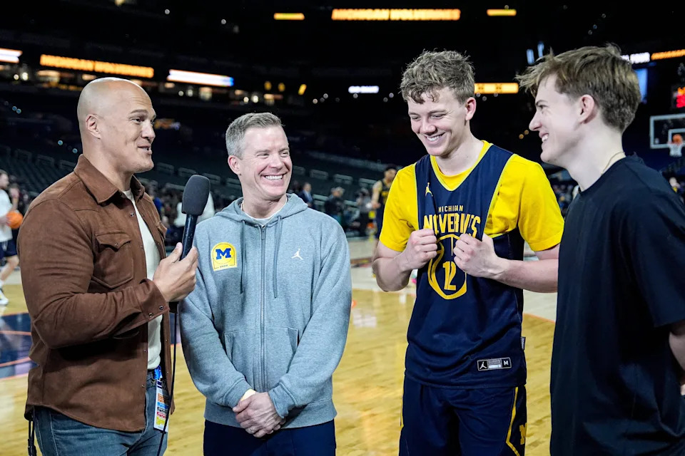 Michigan head coach Dusty May, center left, and his sons guard Charlie May (12), center right, and student manager Eli May during open practice at Lucas Oil Stadium in Indianapolis on Friday, April 3, 2026.