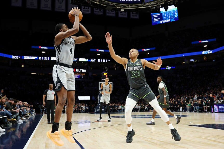 De'aaron Fox of the San Antonio Spurs shoots the ball against Jaylen Clark of the Minnesota Timberwolves.