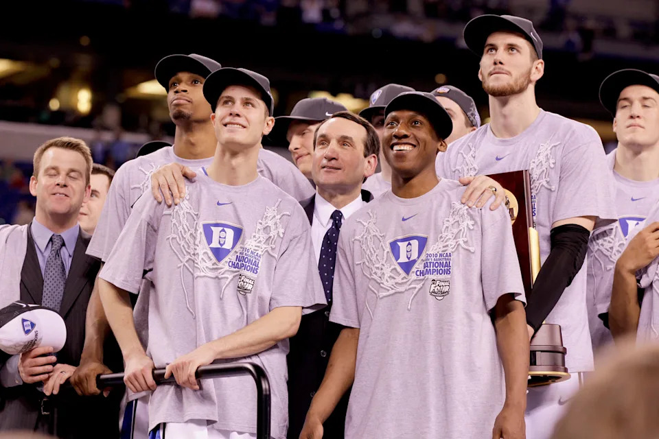 Duke head coach Mike Krzyzewski with arms on the shoulders of Jon Scheyer of Duke (30), left, and Nolan Smith of Duke (2) as they watch "One Shining Moment" during post-game ceremony after defeating Butler, 61-59, in the NCAA Final Four championship game at Lucas Oil Stadiuim in Indianapolis, Indiana, Monday, April 5, 2010.  (Photo by Mark Cornelison/Getty Images)