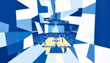 A cubist, geometric painting depicting a fragmented basketball game, with sharp, overlapping planes of light blue, white, and navy colors representing the University of North Carolina