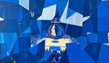 A fragmented, cubist-style painting depicting a Dallas Mavericks basketball game, with the players and court broken down into sharp, overlapping geometric shapes in shades of blue and silver, conveying the disappointment and uncertainty surrounding the team