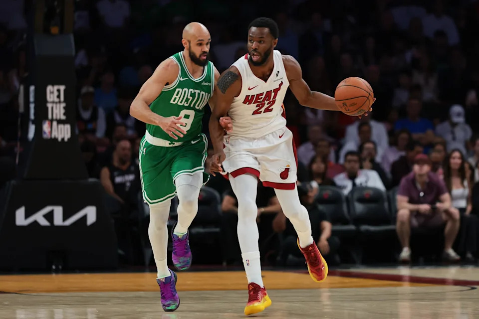 Apr 1, 2026; Miami, Florida, USA; Miami Heat forward Andrew Wiggins (22) protects the basketball against Boston Celtics guard Derrick White (9) during the first quarter at Kaseya Center. Mandatory Credit: Sam Navarro-Imagn Images