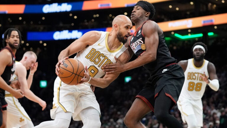 Boston Celtics guard Derrick White (9) is defended by Philadelphia 76ers guard VJ Edgecombe (77) during the first half of an NBA basketball game, Sunday, March 1, 2026, in Boston.