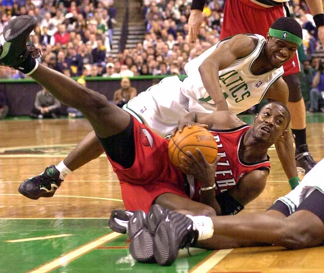 BOSTON, UNITED STATES: Boston Celtics' Shammond Williams (TOP) battles for the ball with Jeff McInnis (BOTTOM) of the Portland Trail Blazers 03 January 2003 at the Fleet Center in Boston, Massachusetts. The Trail Blazers beat the Celtics 103-108. AFP PHOTO/JESSICA RINALDI (Photo credit should read JESSICA RINALDI/AFP via Getty Images)