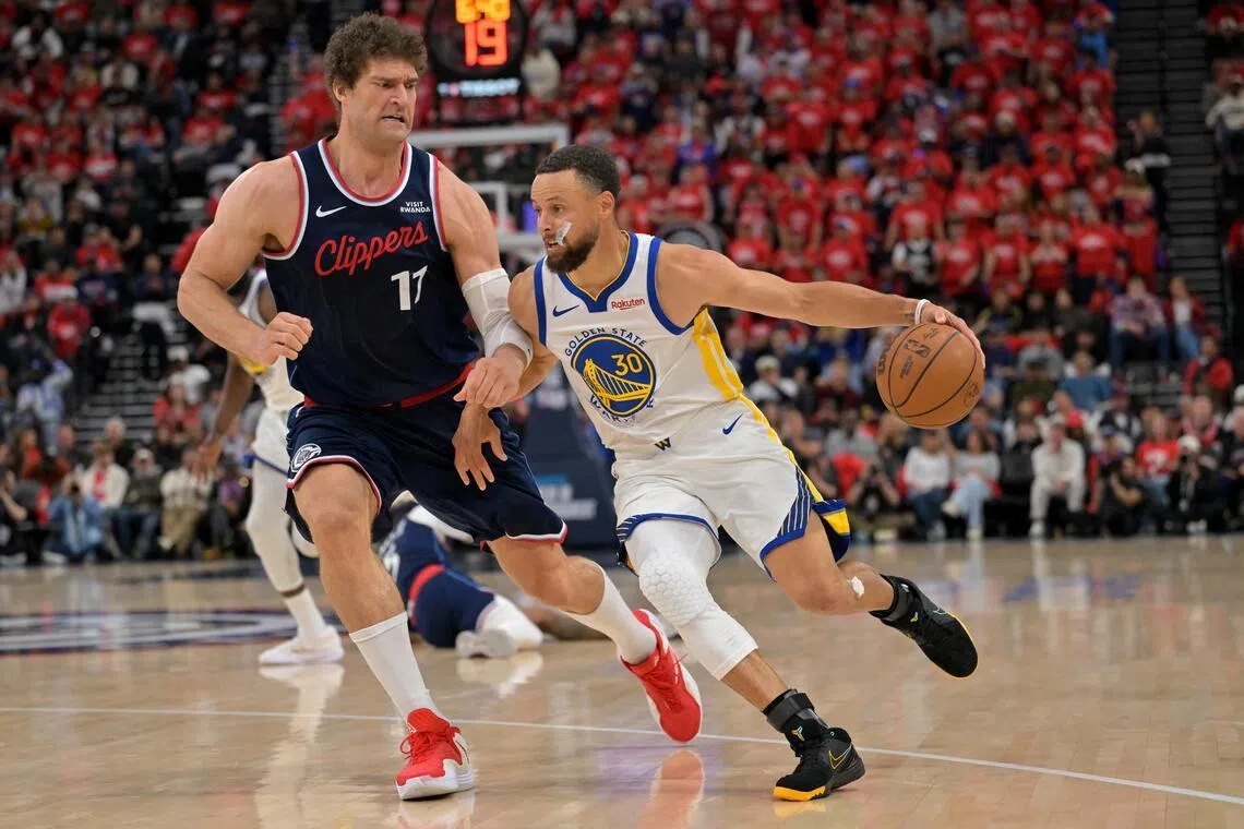 Los Angeles Clippers center Brook Lopez defends Golden State Warriors guard Stephen Curry in the second half at Intuit Dome.