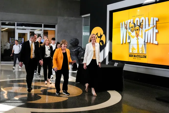 Iowa's new head men's basketball coach Ben McCollum walks into his introductory press conference with his family, President Barbara Wilson and Athletic Director Beth Goetz Tuesday, March 25, 2025 at Carver-Hawkeye Arena in Iowa City, Iowa.