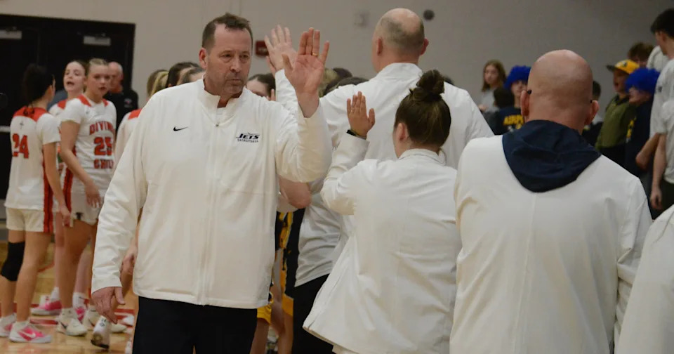 Airport girls basketball coach Darrell Mossburg high-fives his assistant coaches following a 68-60 victory over Dearborn Divine Child in the finals of the Division 2 Regional that Divine Child hosted on Wednesday, March 11, 2026.