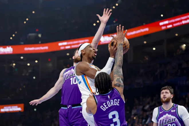 Jan 7, 2026; Oklahoma City, Oklahoma, USA; Oklahoma City Thunder guard Shai Gilgeous-Alexander (2) goes up for a basket between Utah Jazz guard/forward Svi Mykhailiuk (10) and guard Keyonte George (3) during the first quarter at Paycom Center. Mandatory Credit: Alonzo Adams-Imagn Images