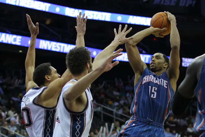 Apr 11; Newark, NJ, USA; Charlotte Bobcats guard Gerald Henderson (15) takes a shot over New Jersey Nets center Brook Lopez (11) and New Jersey Nets center Dan Gadzuric (50) during the second half at the Prudential Center. The Bobcats defeated the Nets 105-103. Mandatory Credit: Ed Mulholland-USA TODAY Sports
