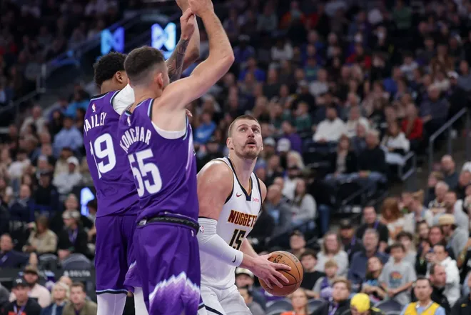 Apr 1, 2026; Salt Lake City, Utah, USA; Denver Nuggets center Nikola Jokić (15) waits for Utah Jazz forward Ace Bailey (19) and guard John Konchar (55) to jump past him before shooting during the second half at Delta Center.