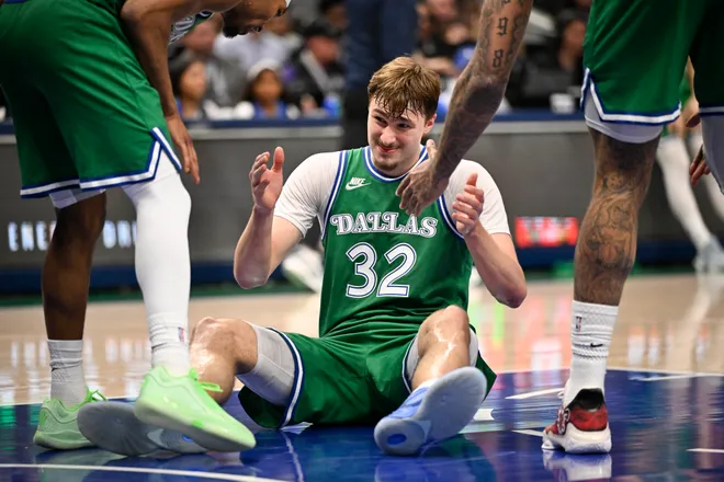 Apr 3, 2026; Dallas, Texas, USA; Dallas Mavericks forward Cooper Flagg (32) is helped up by his teammates during the second half against the Orlando Magic at the American Airlines Center. Mandatory Credit: Jerome Miron-Imagn Images