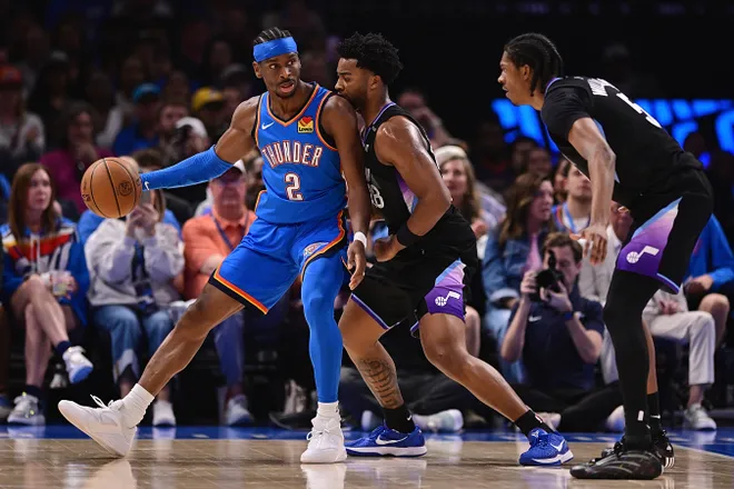 OKLAHOMA CITY, OKLAHOMA - APRIL 5: Shai Gilgeous-Alexander #2 of the Oklahoma City Thunder handles the ball while being defended by Brice Sensabaugh #28 of the Utah Jazz during the first half at Paycom Center on April 5, 2026 in Oklahoma City, Oklahoma. NOTE TO USER: User expressly acknowledges and agrees that, by downloading and or using this photograph, User is consenting to the terms and conditions of the Getty Images License Agreement. (Photo by Joshua Gateley/Getty Images)