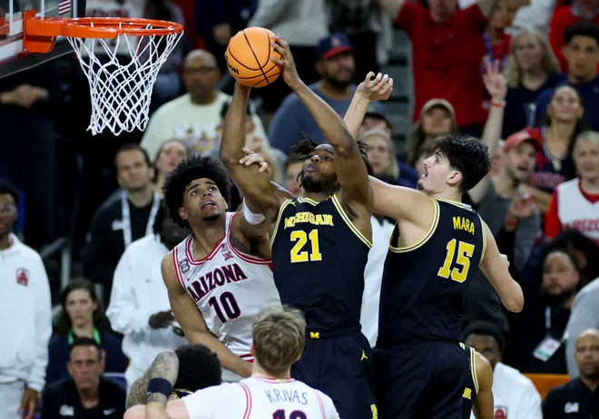 Apr 4, 2026; Indianapolis, IN, USA; Michigan Wolverines forward Morez Johnson Jr. (21) rebounds the ball against Arizona Wildcats forward Koa Peat (10) in the second half during a semifinal of the Final Four of the men's 2026 NCAA Tournament at Lucas Oil Stadium. Mandatory Credit: Trevor Ruszkowski-Imagn Images