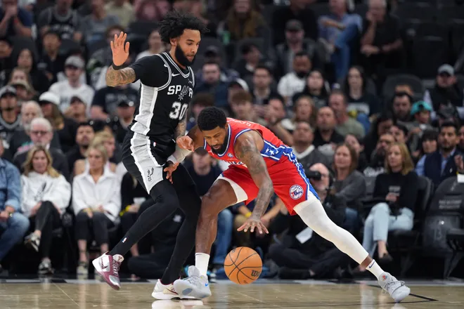Apr 6, 2026; San Antonio, Texas, USA; Philadelphia 76ers forward Paul George (8) reaches for a loose ball while defended by San Antonio Spurs forward Julian Champagnie (30) during the first half at Frost Bank Center. Mandatory Credit: Scott Wachter-Imagn Images
