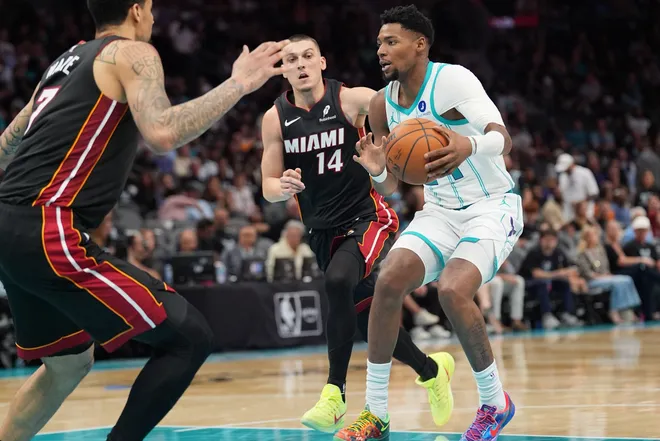 Apr 14, 2026; Charlotte, North Carolina, USA; Charlotte Hornets forward Brandon Miller (24) handles the ball guarded by Miami Heat guard Tyler Herro (14) and center Kel'el Ware (7) during the second half during the play-in rounds between the Charlotte Hornets and the Miami Heat of the 2026 NBA Playoffs at Spectrum Center. Mandatory Credit: Jim Dedmon-Imagn Images