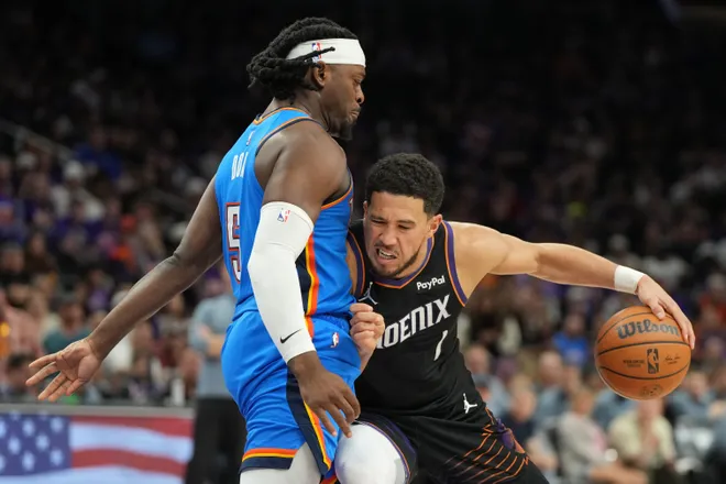 Apr 25, 2026; Phoenix, Arizona, USA; Phoenix Suns guard Devin Booker (1) drives on Oklahoma City Thunder guard Luguentz Dort (5) in the second half during game three of the first round of the 2026 NBA Playoffs at Mortgage Matchup Center. Mandatory Credit: Rick Scuteri-Imagn Images