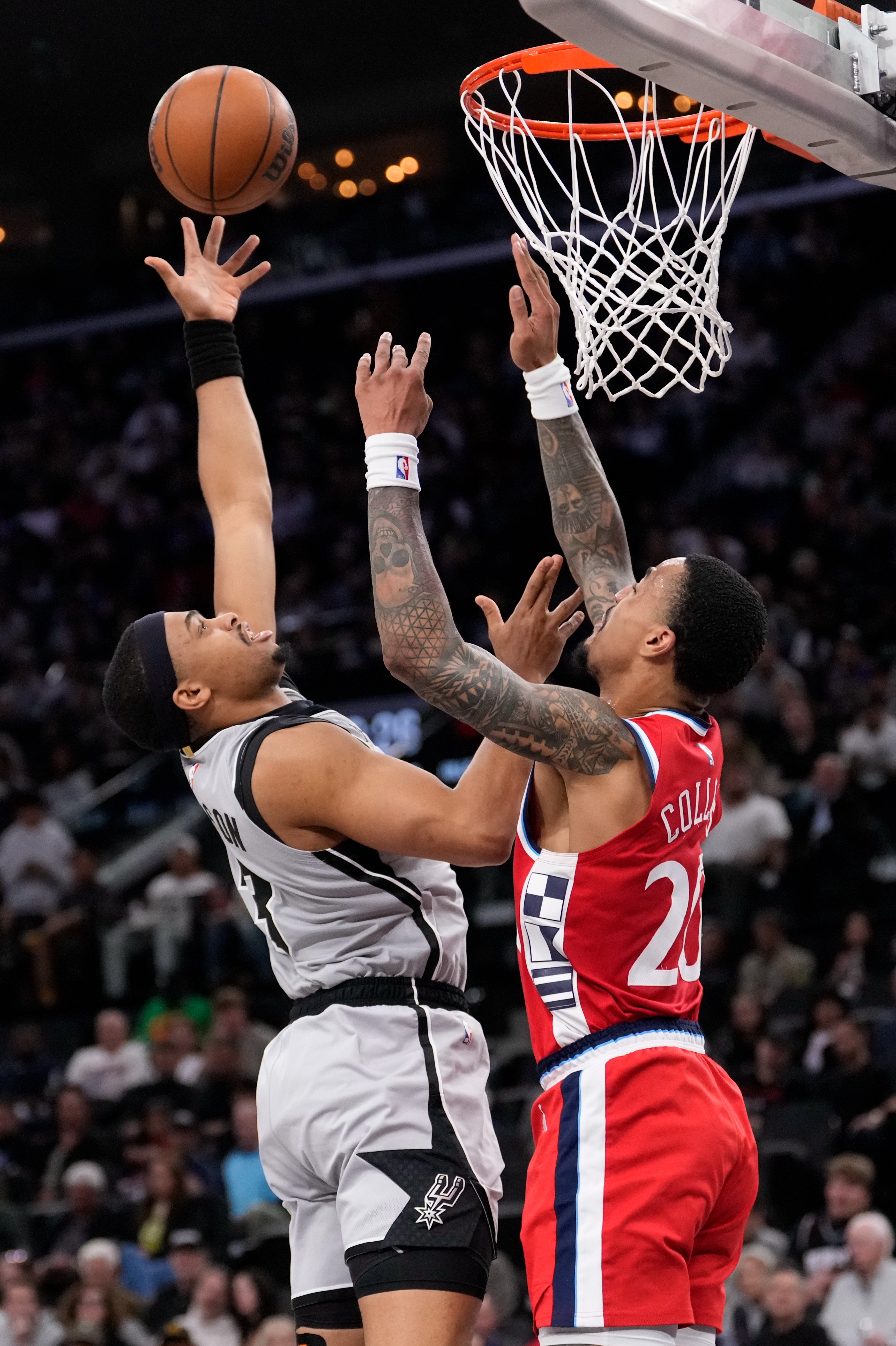 San Antonio Spurs forward Keldon Johnson, left, shoots as Clippers...