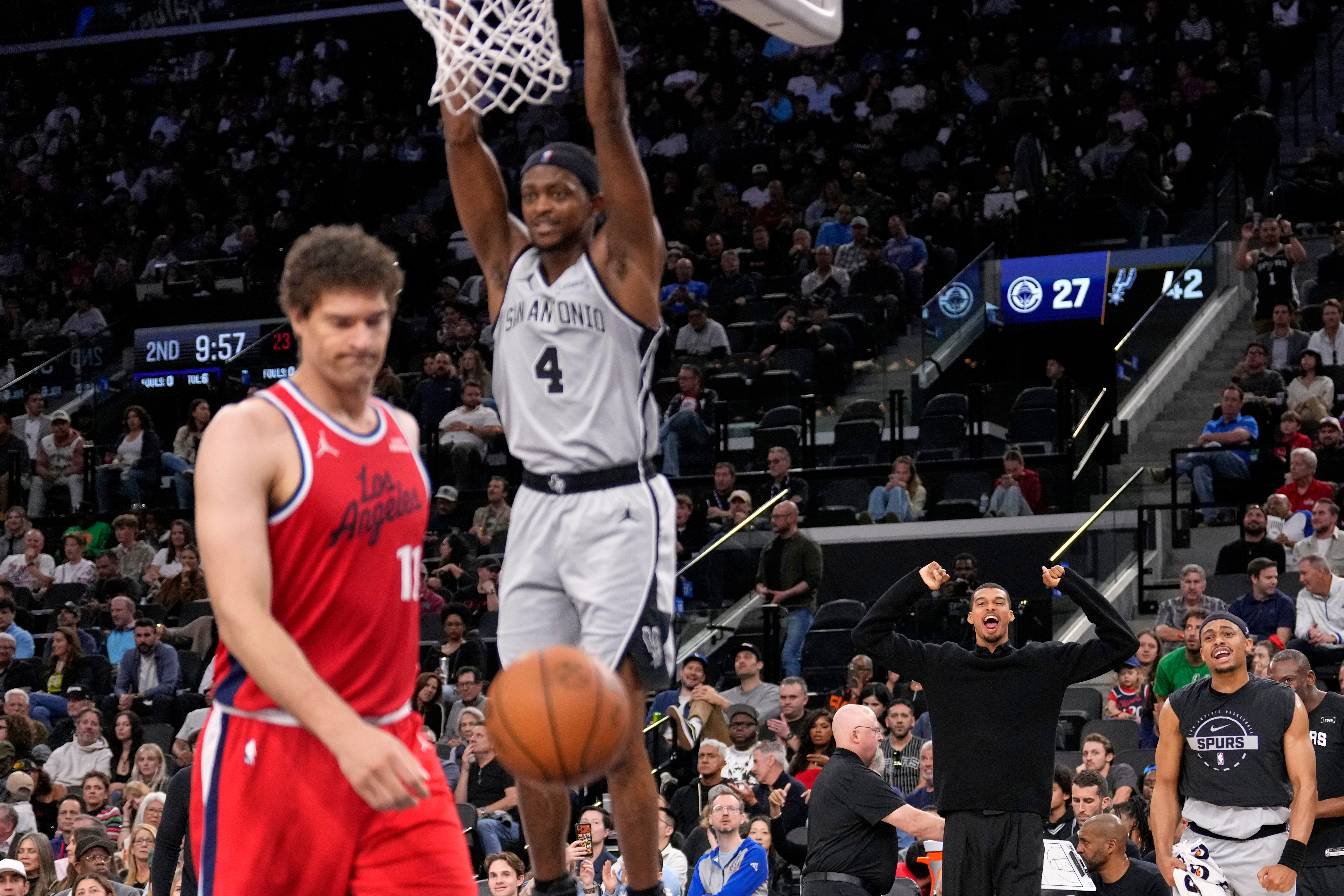 San Antonio Spurs guard De’Aaron Fox, hangs from the rim...