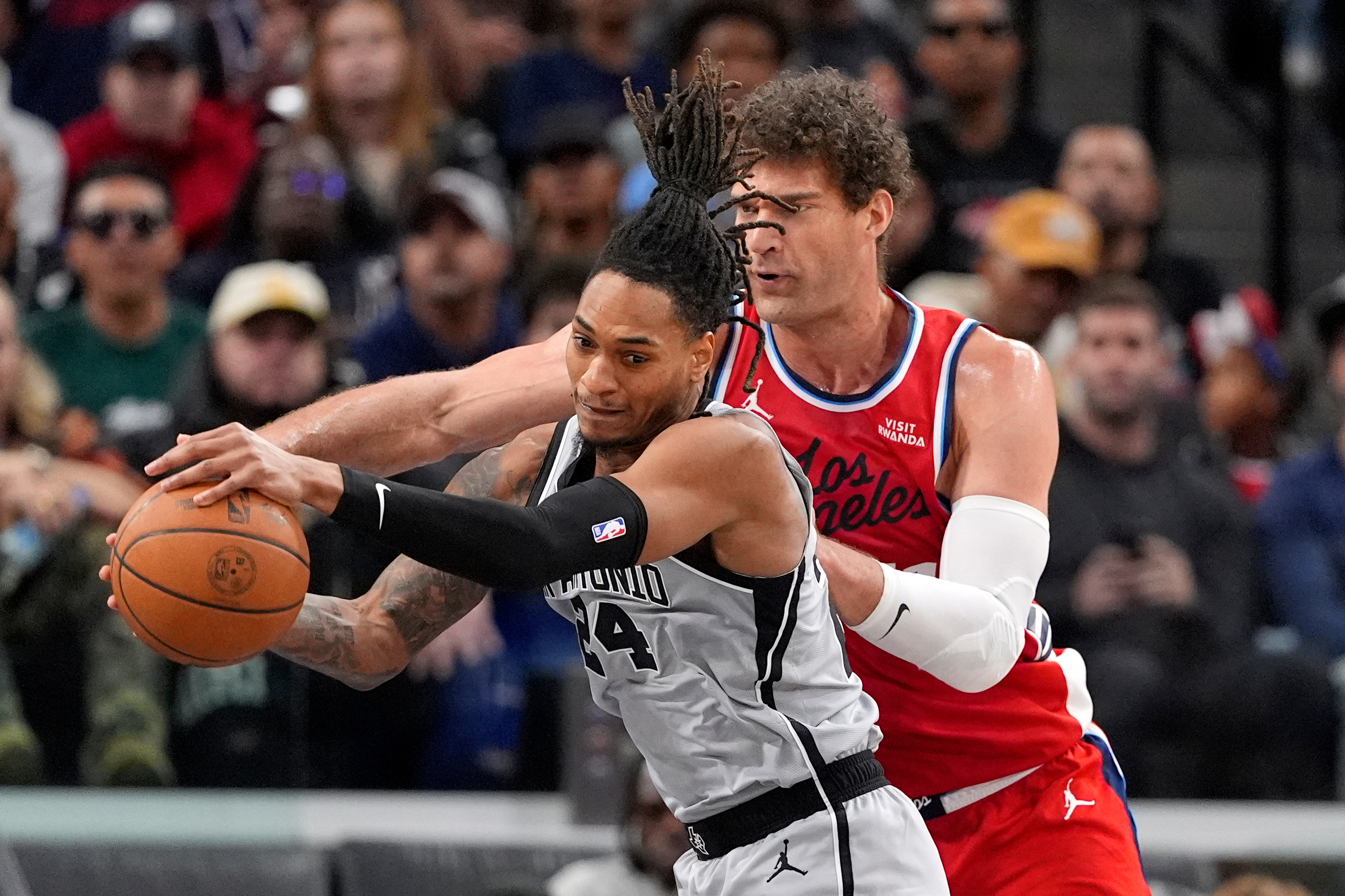 San Antonio Spurs guard Devin Vassell, left, grabs a rebound...
