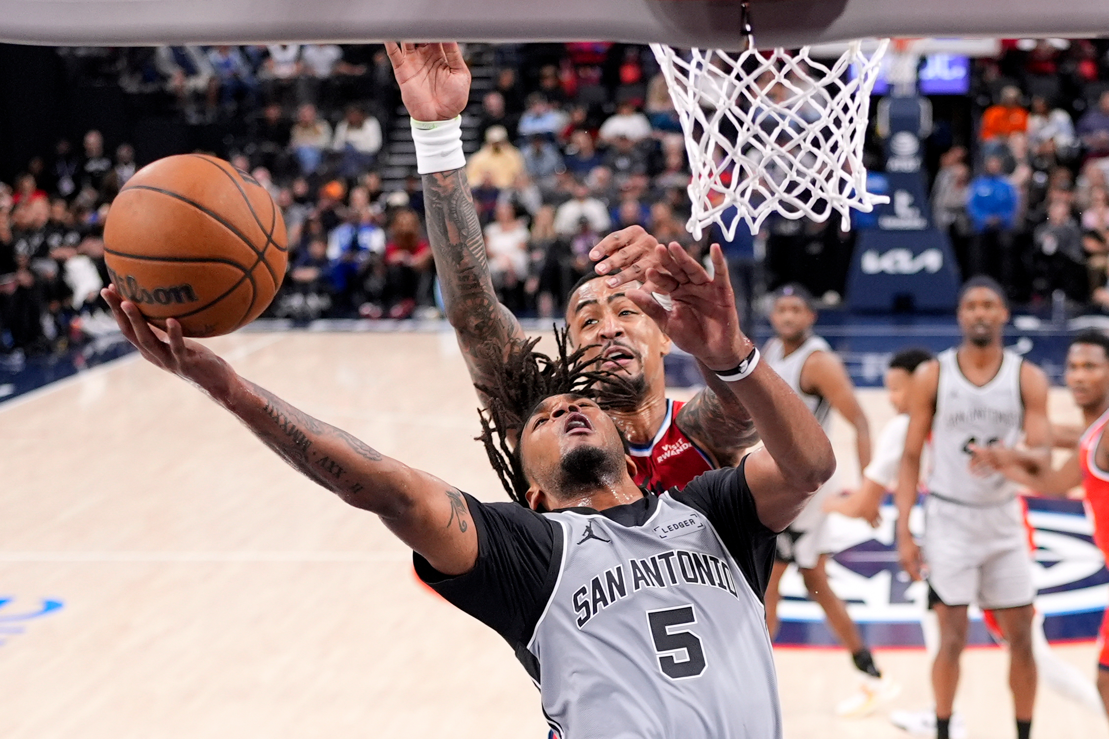 San Antonio Spurs guard Stephon Castle, below, shoots as Clippers...