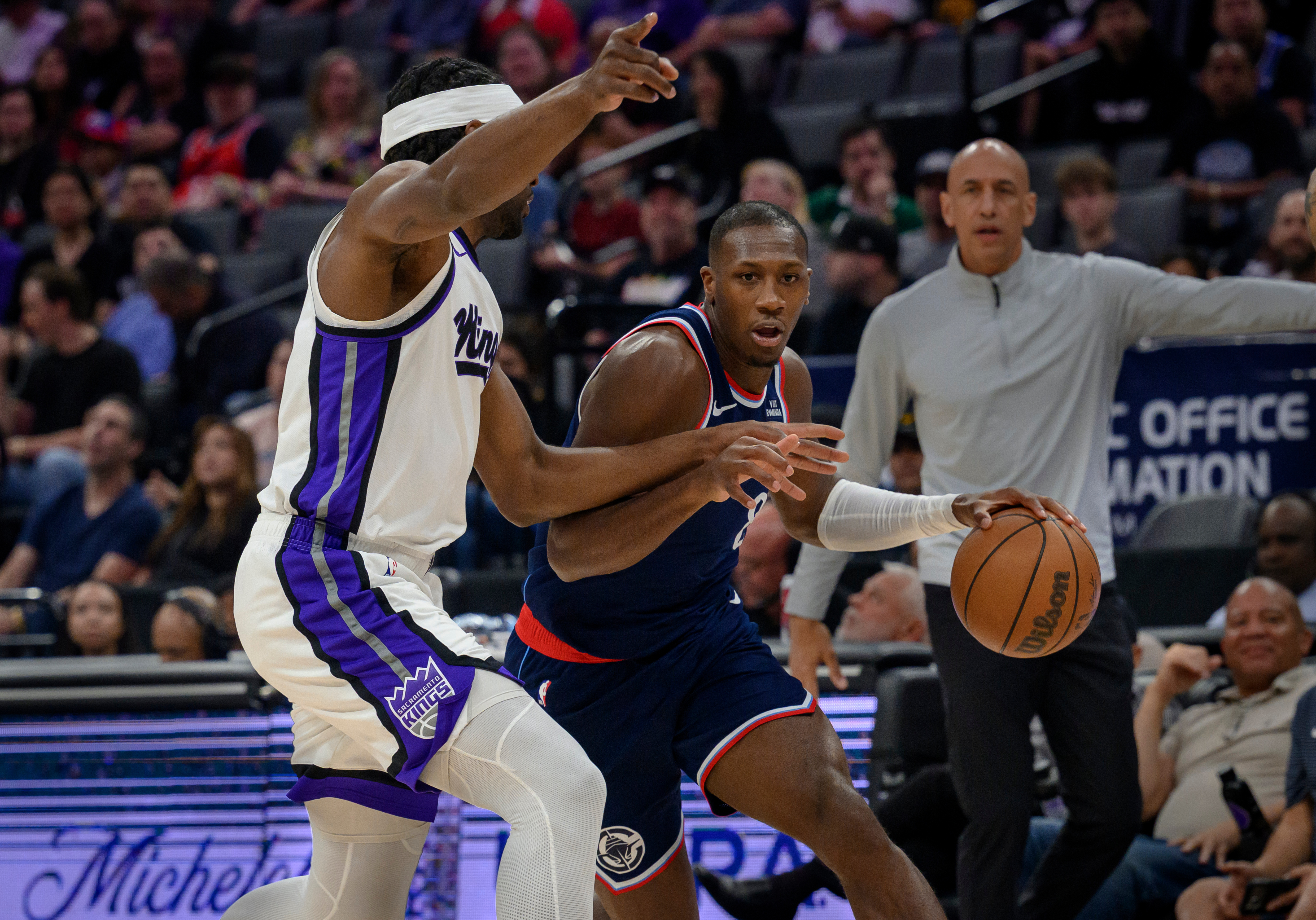 Clippers guard Kris, center, Dunn is guarded by Sacramento Kings...