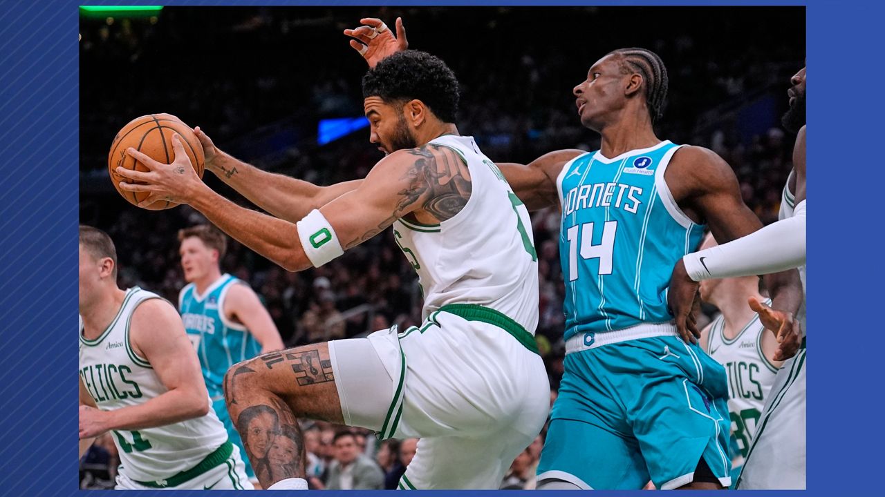 Boston Celtics forward Jayson Tatum, left, grabs a rebound against Charlotte Hornets forward Moussa Diabate (14) during the first half of a NBA basketball game, Tuesday, April 7, 2026, in Boston. (AP Photo/Charles Krupa)