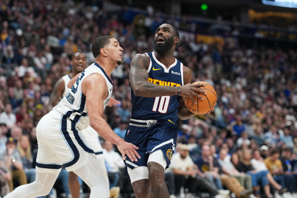 Denver Nuggets guard Tim Hardaway Jr., right, drives to the rim as Memphis Grizzlies guard Lucas Williamson defends in the second half of an NBA basketball game Wednesday, April 8, 2026, in Denver. (AP Photo/David Zalubowski)