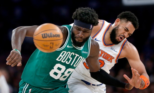 Boston Celtics center Neemias Queta, left, and New York Knicks center Karl-Anthony Towns battle for a loose ball during the first half of an NBA game Thursday, April 9, 2026, in New York. (AP Photo/John Munson)
