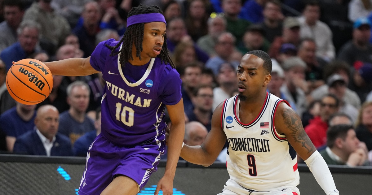 Mar 20, 2026; Philadelphia, PA, USA; Furman Paladins guard Alex Wilkins (10) dribbles the ball past UConn Huskies guard Alec Millender (9) in the second half during a first round game of the men's 2026 NCAA Tournament at Xfinity Mobile Arena. Mandatory Credit: Kyle Ross-Imagn Images