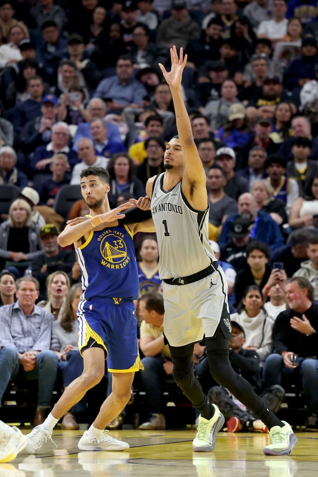 San Antonio Spurs' Victor Wembanyama (1) raises his hand to get the ball as Golden State Warriors' Malevy Leons (33) in the second quarter of an NBA game at Chase Center in San Francisco, Calif., on Wednesday, April 1, 2026. (Ray Chavez/Bay Area News Group)