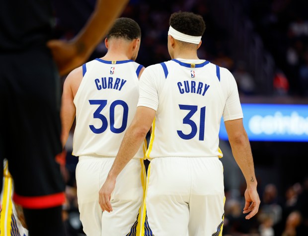 Golden State Warriors' Stephen Curry (30) and Golden State Warriors' Seth Curry (31) walk on the court during a break in action against the Houston Rockets in the third quarter at the Chase Center in San Francisco, Calif., on Sunday, April 5, 2026. (Nhat V. Meyer/Bay Area News Group)