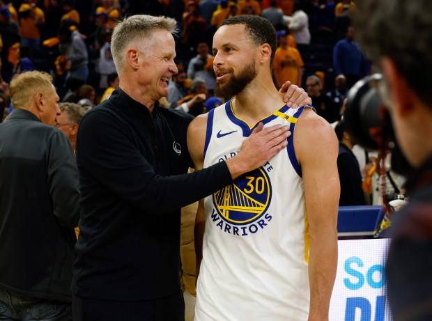 Golden State Warriors head coach Steve Kerr talks with Golden State Warriors' Stephen Curry (30) after their 124-119 win over the Memphis Grizzlies for their NBA play-in tournament game at the Chase Center in San Francisco, Calif., on Tuesday, April 15, 2025. (Nhat V. Meyer/Bay Area News Group)