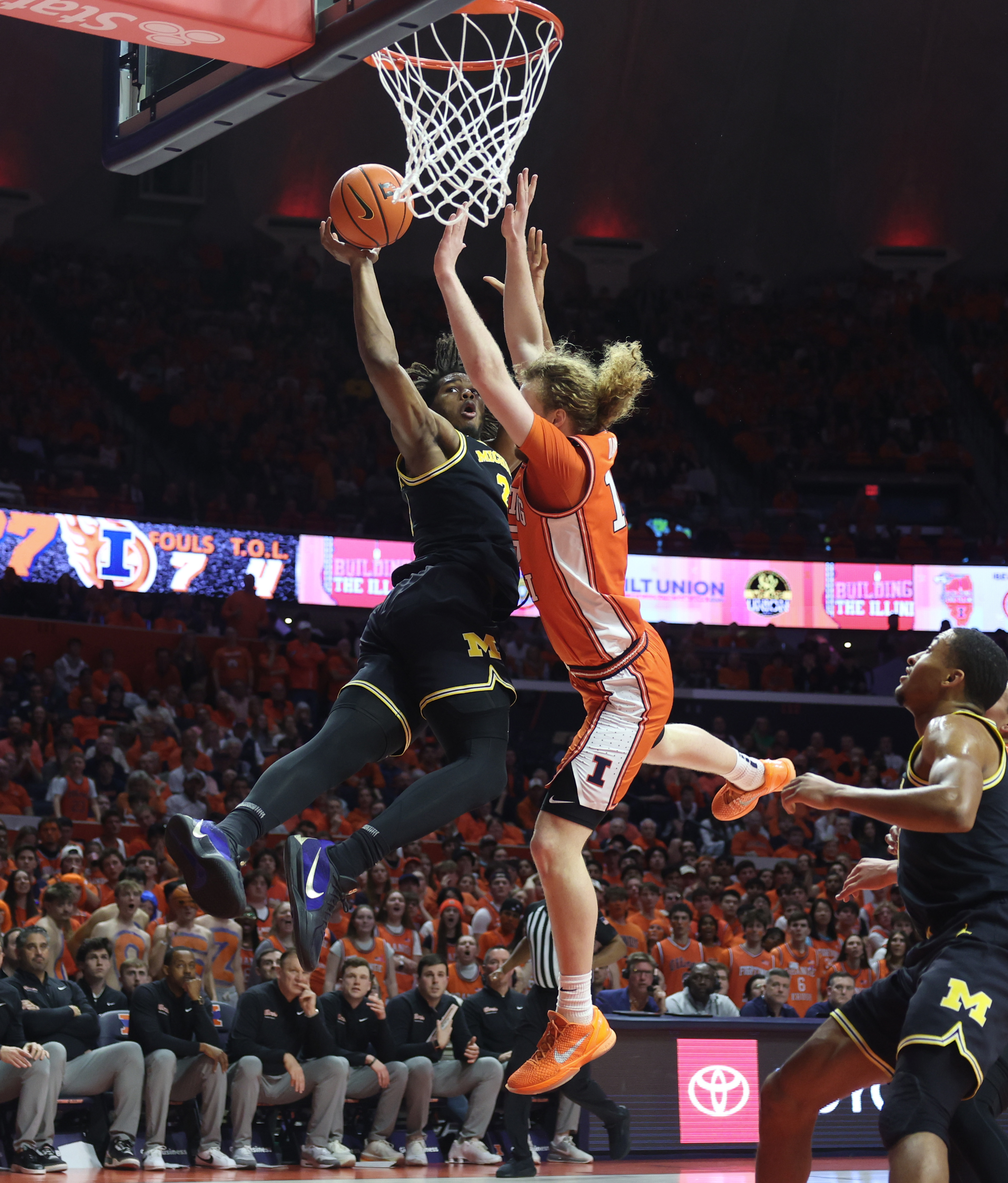 Michigan forward Morez Johnson Jr., left, is fouled by Illinois...