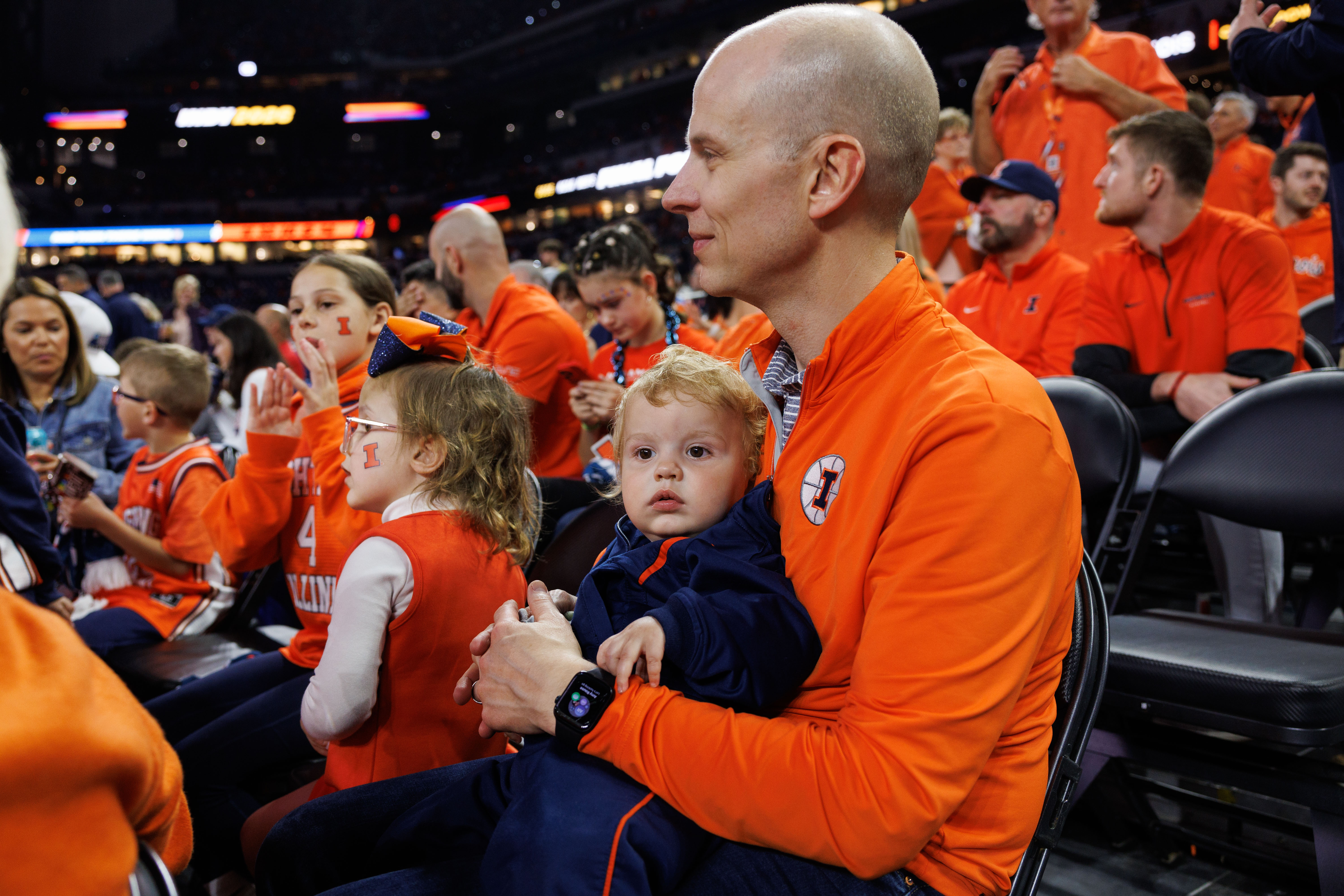 Kurt Bloomstrand holds his 1-year-old son, Jospeh, before Illinois' Final...
