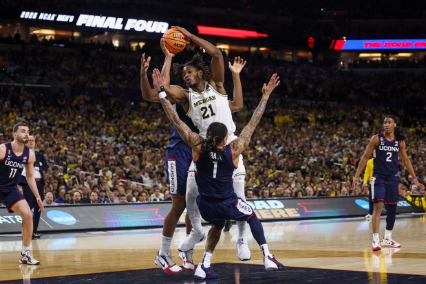 UConn guard Solo Ball (1) fouls Michigan forward Morez Johnson Jr. (21) during the first half of the NCAA title game between UConn and Michigan April 6, 2026, at Lucas Oil Stadium in Indianapolis. (Armando L. Sanchez/Chicago Tribune)