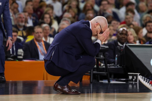 UConn head coach Dan Hurley kneels on the court during the first half of the NCAA title game between UConn and Michigan April 6, 2026, at Lucas Oil Stadium in Indianapolis. (Armando L. Sanchez/Chicago Tribune)