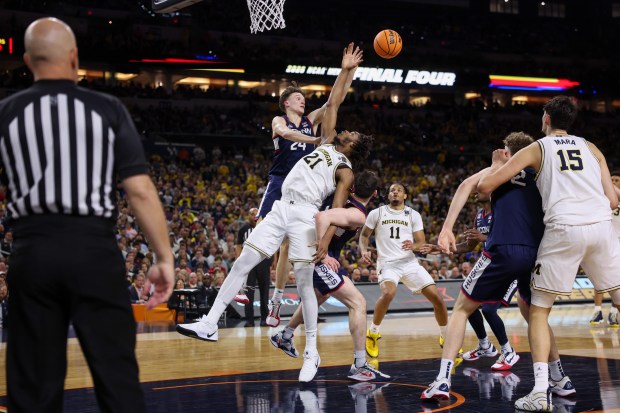 UConn forward Alex Karaban (11) fouls Michigan forward Morez Johnson Jr. (21) during the first half of the NCAA title game between UConn and Michigan April 6, 2026, at Lucas Oil Stadium in Indianapolis. (Armando L. Sanchez/Chicago Tribune)