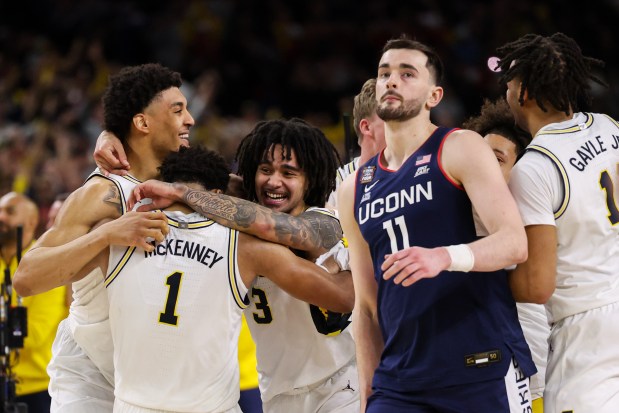 Michigan players celebrate after defeating UConn, 69-63, in the NCAA title game on April 6, 2026, at Lucas Oil Stadium in Indianapolis. (Armando L. Sanchez/Chicago Tribune)