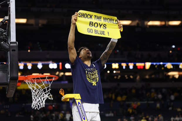 Michigan forward Yaxel Lendeborg (23) celebrates with his team after defeating UConn, 69-63, in the NCAA title game on April 6, 2026, at Lucas Oil Stadium in Indianapolis. (Armando L. Sanchez/Chicago Tribune)
