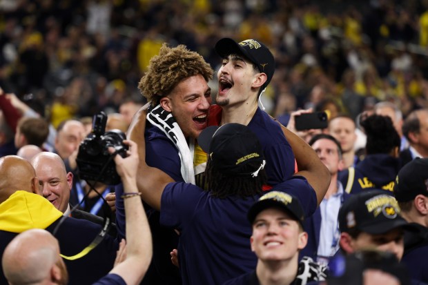 Michigan center Aday Mara (15) celebrates with Michigan center Malick Kordel (32) and their team after defeating UConn, 69-63, in the NCAA title game on April 6, 2026, at Lucas Oil Stadium in Indianapolis. (Armando L. Sanchez/Chicago Tribune)
